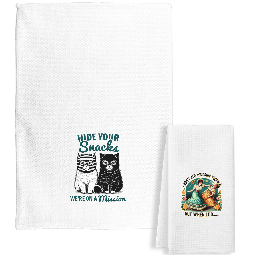 Tea towels with waffle weave and funny sayings, cute designs, folded stacks and cups on a light showroom table.